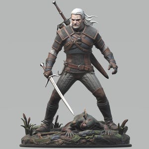 May include: A detailed figurine of a white-haired warrior in dark leather and chainmail armor, holding a silver sword in one hand. A second sword is strapped to the back. The figure stands over a defeated, dark-skinned creature on a rocky base.