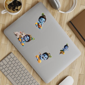 Könnte beinhalten: Ein Set aus vier Vinyl-Aufklebern, die eine blauhäutige Gottheit in verschiedenen Posen zeigen: beim Essen aus einem Topf, mit einem Kalb, beim Flötenspiel und beim Tanzen. Jeder Aufkleber zeigt die Figur mit einer Pfauenfeder im Haar.