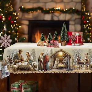 Peut inclure: Une nappe de couleur crème ornée d'une scène de nativité imprimée représentant Marie, Joseph et l'enfant Jésus dans une crèche, entourés de moutons, d'ânes et de bergers, avec un bord festonné et un décor de forêt hivernale.