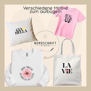 Könnte beinhalten: Eine Auswahl an Artikeln mit Aufbügelmotiven: ein weißes Kissen mit 'CIA BELLA' und Zitrone, ein rosa T-Shirt mit 'BONJOUR' und Sonnenbrille, ein weißes Sweatshirt mit rosa Blume und Text sowie eine weiße Tragetasche mit 'LA VIE' und einer Schleife.