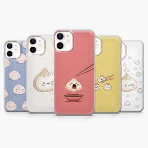 Könnte beinhalten: Fünf Smartphone-Hüllen mit verschiedenen Knödel-Illustrationen. Die Designs umfassen eine blaue Hülle mit Knödelmuster, eine transparente Hülle mit einem einzelnen Knödel, eine rosa Hülle mit Knödel und Stäbchen, eine gelbe Hülle und eine weiße Hülle.