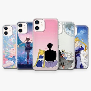 Può includere: Cinque cover trasparenti per smartphone con varie illustrazioni dell'anime Sailor Moon. I design includono personaggi in pose romantiche, davanti a una grande luna e circondati da motivi floreali, tutti con fori per la doppia fotocamera.