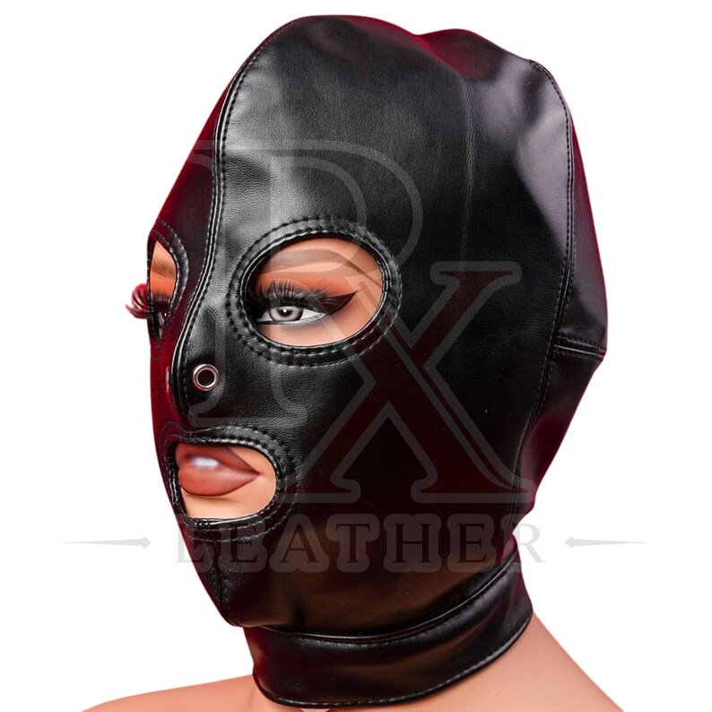 May include: A black full-head mask featuring a smooth finish with cutouts for the eyes and mouth. The mask includes a silver-toned metal eyelet on the nose bridge and visible stitching along the seams. The design covers the head and neck.