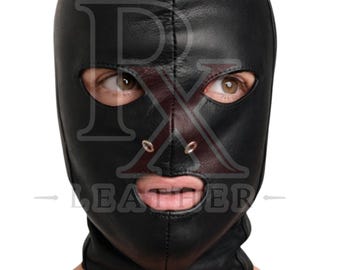 May include: A black leather hood featuring a full-face design with cutouts for the eyes, nose, and mouth. The nose area includes two small metal eyelets. The text RX LEATHER is overlaid across the center of the black leather head covering.
