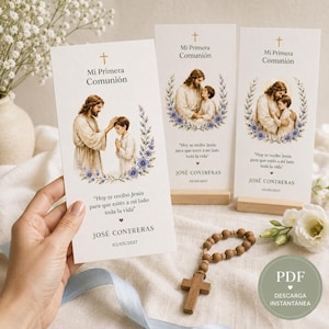Puede incluir: Tres tarjetas rectangulares de papel blanco para una Primera Comunión, cada una con una cruz dorada, una ilustración de Jesús con un niño, detalles florales azules y el texto "Mi Primera Comunión" con un nombre y fecha impresos.
