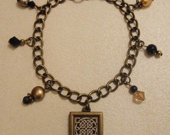 Antique Brass 17mm Framed Celtic Knot Bracelet with Black Onyx Beads, Fresh Water Pearls, and Swarovski Crystals.