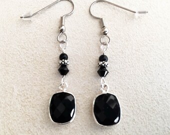 May include: Black gemstone earrings with silver accents and black beads. The earrings are dangle style and feature a rectangular black gemstone.