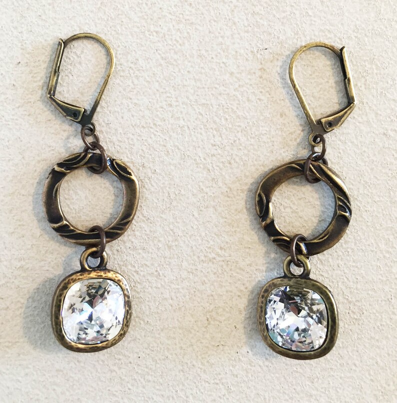 Sparkly Tierra Cast Crystal Charm on Brass Oxide Pewter Flora Rings Dangling from Antique Brass Lever Back Earrings.