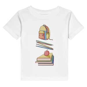 Op de afbeelding: Een wit t-shirt met korte mouwen en een gecentreerde grafische illustratie van een gele en blauwe rugzak, een groep van vier geslepen potloden en een stapel van drie boeken met een enkele rode appel erbovenop, gerangschikt in een verticale kolom.