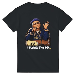 Puede incluir: Una camiseta negra con un gráfico de una persona con boina azul, gafas de sol y un chándal azul con la palabra FAUCI en el pecho. La persona sostiene un micrófono en un escritorio con un papel etiquetado como FIF y el texto I PLEAD THE FIF.