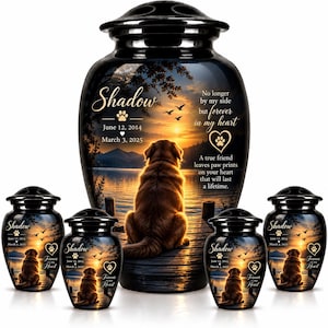 May include: A large black cremation urn and four smaller matching urns featuring a sunset lake scene with a dog sitting on a dock. The text reads Shadow, June 12, 2014, March 3, 2025, No longer by my side but forever in my heart, and A true friend leaves paw prints on your heart that will last a lifetime.