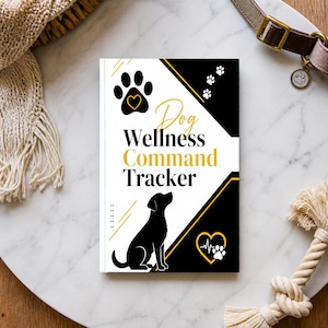 May include: A rectangular book titled Dog Wellness Command Tracker with a black and white cover featuring a silhouette of a dog, a paw print with a heart, and a heart icon with an EKG line. The design includes gold accents and paw print graphics.