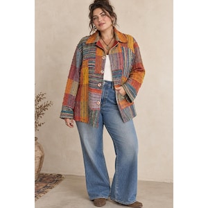 May include: A long-sleeve button-down jacket featuring a multi-colored patchwork design with shades of orange, blue, yellow, and red, worn over a plain white top paired with light blue denim jeans with a wide-leg silhouette.