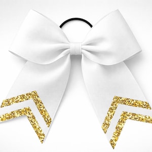May include: White cheerleading bow with gold glitter chevron accents. The bow is tied with a black elastic band. This hair accessory is perfect for cheerleaders, dancers, or anyone wanting a stylish hair accessory.