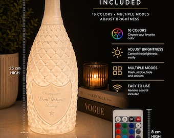 Könnte beinhalten: Eine weiße, texturierte Champagnerflaschen-Lampe mit Dom Pérignon-Logo, 25 cm hoch und 10 cm im Durchmesser. Sie enthält eine 8 cm hohe und 5 cm breite Fernbedienung für 16 Farben, Helligkeitsanpassung und verschiedene Lichtmodi.