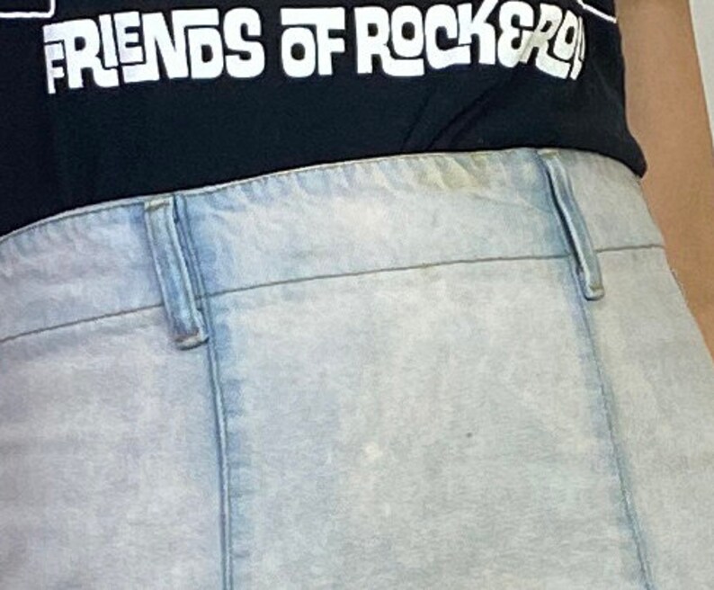 May include: A pair of light blue denim jeans with a light wash. The jeans have a button fly and belt loops. The jeans are worn and have a faded appearance.