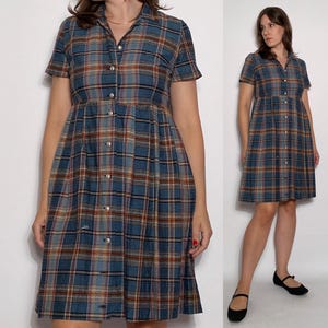 May include: A blue and brown checked button-down dress with short sleeves and a knee-length skirt.