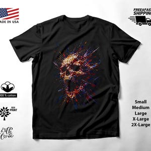 May include: A black short-sleeve t-shirt featuring a central graphic of a skull with an open jaw, rendered in a vibrant, multi-colored paint splatter style with streaks of red, blue, yellow, and white radiating outward from the skull.