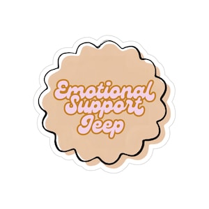 May include: A circular sticker with a scalloped edge featuring a light tan background and a black outline. The text 'Emotional Support Jeep' is written in a retro-style, light pink cursive font with a brown outline centered on the sticker.