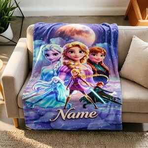 Könnte beinhalten: Eine weiche Fleecedecke mit einem lebendigen violetten und blauen Nachthimmel-Hintergrund und einem großen Mond. Das Design zeigt fünf animierte Figuren in verschiedenen Posen, mit dem Wort Name in weißer Schreibschrift unten in der Mitte.