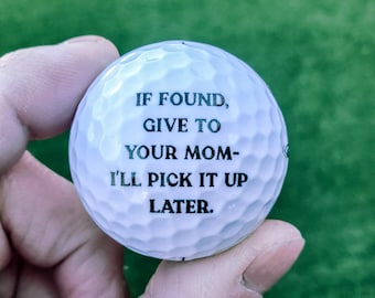 May include: A white golf ball with black text that reads "If found, give to your mom - I'll pick it up later."
