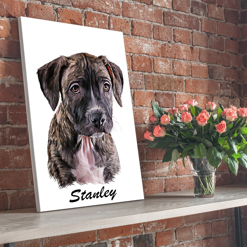 Op de afbeelding: Een canvasprint met een close-up portret van een bruine en zwarte gevlekte puppy met de naam "Stanley" onder de afbeelding.