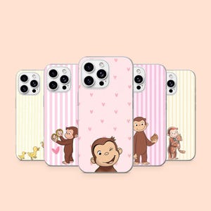Op de afbeelding: Vijf smartphonehoesjes met Curious George-illustraties. De ontwerpen bevatten gele en roze verticale strepen, een roze achtergrond met kleine hartjes en diverse scènes van de bruine aap met eendjes, koekjes en een kat.