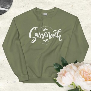 May include: A green sweatshirt with a white graphic print that says "Sassenach" with a floral design and the text "Sassenach is the new style" and "Craig na Dun".