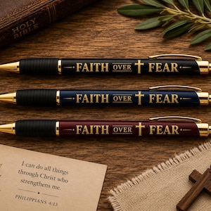 May include: Three retractable ballpoint pens in black, navy blue, and maroon, each featuring gold-tone accents, a black rubber grip, and the gold-printed text FAITH OVER FEAR with a cross symbol between the words.