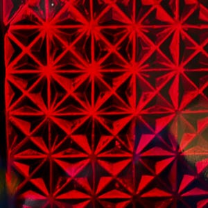 May include: A vibrant red surface featuring a repeating geometric pattern of raised, three-dimensional pyramids. The structure creates a grid of intersecting lines and triangular facets that catch light, producing varying shades of deep crimson.
