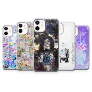 May include: Five clear smartphone cases featuring distinct graphic designs. The designs include a colorful collage, a dark abstract portrait, a black and white photograph of a person with text, and a purple-toned illustration with stylized lettering.