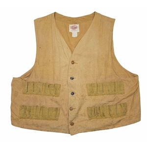 May include: A tan sleeveless vest featuring a V-neckline, a five-button front closure, and four exterior pockets with elasticized openings. A white rectangular label with red and black text is sewn into the interior neckline of the garment.