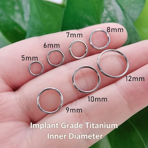 May include: A collection of silver-colored circular rings made of implant grade titanium, labeled with inner diameters of 5mm, 6mm, 7mm, 8mm, 9mm, 10mm, and 12mm. The text Implant Grade Titanium Inner Diameter is printed at the bottom of the image.