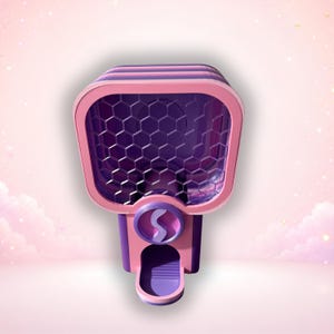 Può includere: Un distributore rosa e viola con un contenitore quadrato e un pannello frontale a nido d'ape. L'unità include una manopola circolare con una lettera S al centro e un piccolo vassoio di erogazione nella parte inferiore per piccoli oggetti.