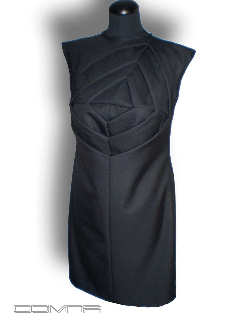 May include: A black sleeveless dress with a geometric design on the bodice. The dress is fitted and has a straight skirt.