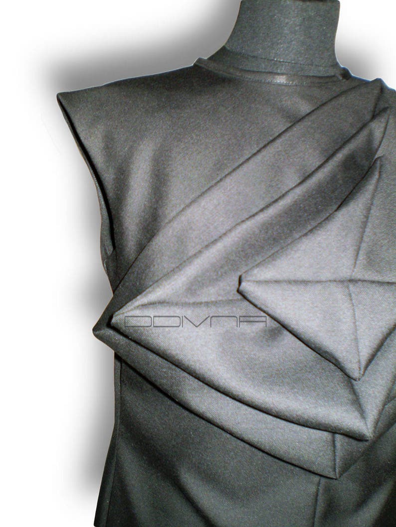 May include: A black sleeveless shirt with a unique folded design. The fabric is folded in a way that creates a series of triangular shapes.