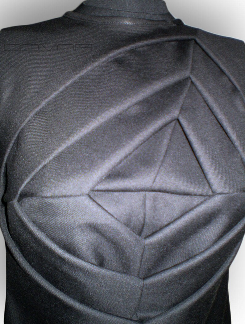 May include: Black sleeveless shirt with a geometric design created by pleats in the fabric.