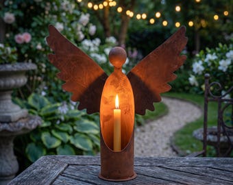 May include: A rust-coloured metal candle holder shaped like an angel with outstretched wings. The cylindrical body features a hollow centre containing a single lit cream-coloured taper candle. The head is represented by a simple metal sphere.
