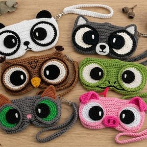 Puede incluir: Seis bolsos de muñeca tejidos a ganchillo con formas de animales: panda, mapache, búho, rana, gato y cerdo. Cada bolso cuenta con grandes ojos circulares, una correa para la muñeca y un cierre de cremallera. Diseños hechos con hilo colorido.