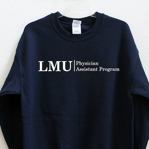 Op de afbeelding: Donkerblauwe trui met witte tekst die "LMU Physician Assistant Program" luidt.