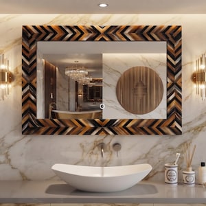 May include: A rectangular wall mirror featuring a frame with a repeating chevron pattern in shades of black, brown, and tan. The mirror includes a small circular touch-sensitive power button at the bottom centre for integrated LED lighting.