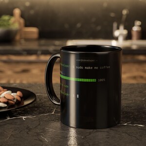 May include: A black ceramic mug featuring green terminal text that reads user@developer:~$ sudo make me coffee, followed by a loading bar at 100%, the text ready to code, and a final command prompt line with a blinking cursor symbol.