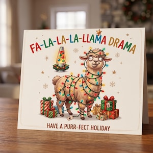 May include: A square greeting card featuring a tan llama wrapped in colorful Christmas lights. The text reads FA-LA-LA-LA-LLAMA DRAMA and HAVE A PURR-FECT HOLIDAY. A lava lamp and several wrapped gift boxes surround the llama on a cream background.
