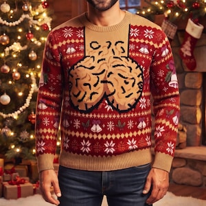 May include: A long-sleeve knit jumper featuring a red and tan colour scheme with a repeating pattern of white snowflakes and bells. The centre of the chest displays a large, tan, brain-shaped graphic with black outlines and textured details.