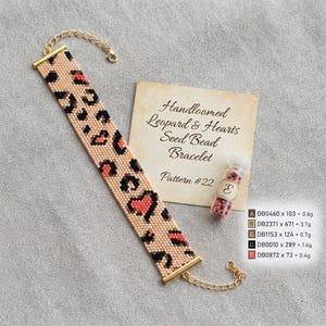 Puede incluir: Una pulsera de cuentas tejida a mano con un patrón de leopardo y corazones integrados en tonos beige, negro y coral. La pulsera incluye terminales de metal dorado y una cadena extensora. Se incluye un pequeño frasco con cuentas.
