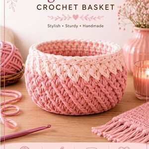 Op de afbeelding: Een ronde gehaakte mand met een tweekleurig diagonaal steekpatroon in roze en lichtroze. De tekst luidt Diagonal Stitch CROCHET BASKET, Stylish, Sturdy, Handmade, Beginner Friendly, Works Up Quickly, Perfect for Storage & Decor, Made with Love.