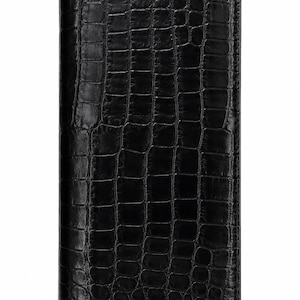 Puede incluir: Una cartera rectangular de color negro con acabado brillante y un patrón texturizado de piel de cocodrilo. La cartera tiene una orientación vertical delgada con bordes rectos y un diseño uniforme en toda la superficie frontal.