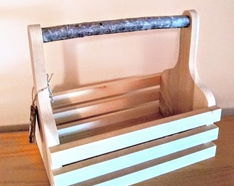 May include: A wooden crate with a natural wood finish and a light blue painted interior. The crate has a handle made of a natural branch.