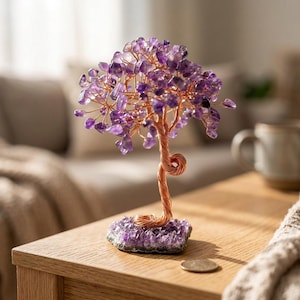 Könnte beinhalten: Eine dekorative Baumskulptur mit einem Stamm und Ästen aus gedrehtem Kupferdraht, die mit zahlreichen kleinen, polierten violetten Amethyst-Edelsteinen besetzt sind. Der Baum ist auf einer Basis aus rohen Amethystkristallen befestigt.