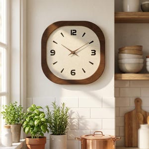 May include: A square wall clock with a dark brown wooden frame and a light beige speckled face. The clock features black numerals at the 12, 3, 6, and 9 o'clock positions, with simple black tick marks for the remaining hours and thin brown hands.